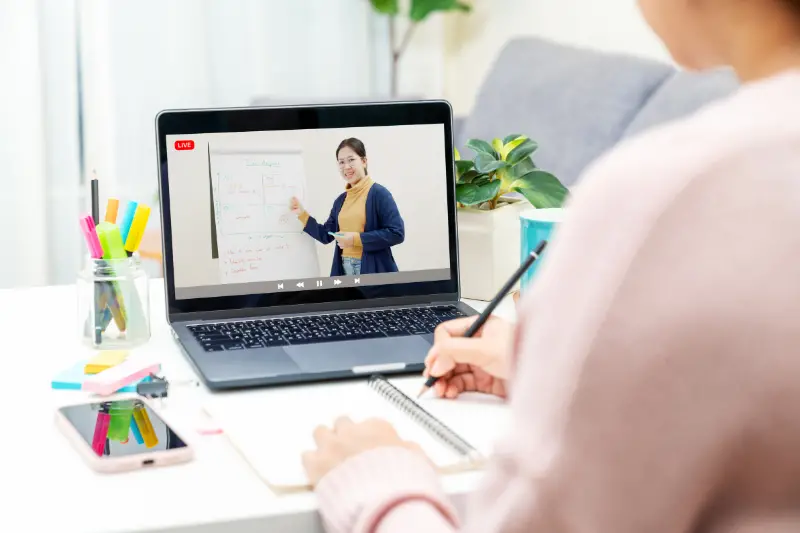 Rear view of a young female student attending the online class