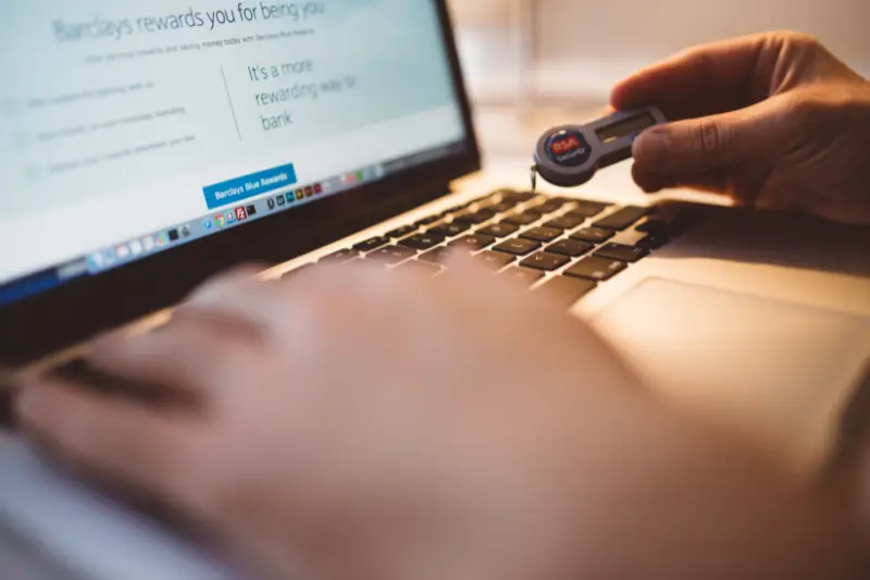 Person working on his laptop holding a usb drive