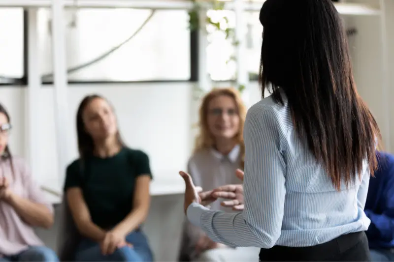 Female coach talking in front of participants