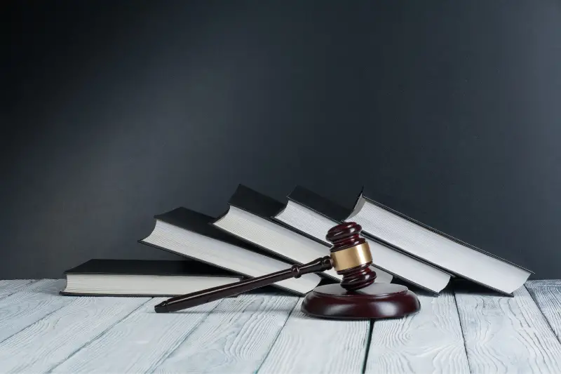 Open law book with a wooden judge gavel on table