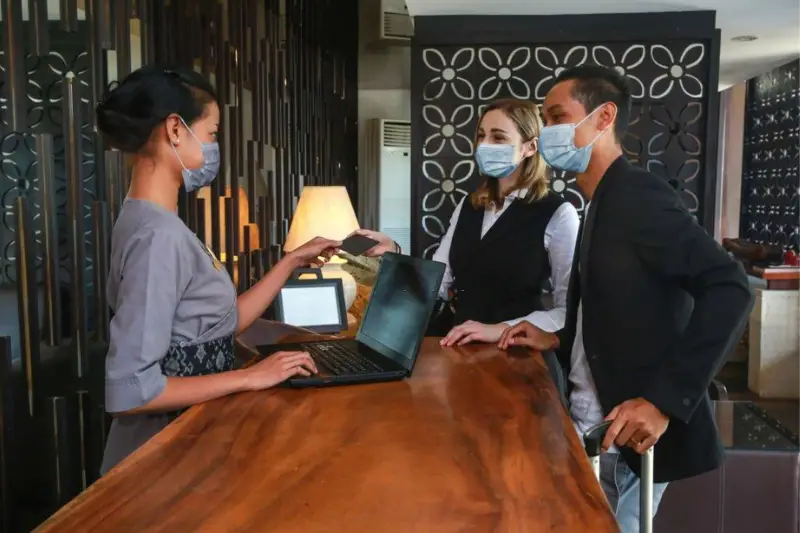 Woman receptionist assisting customers on hotel lobby