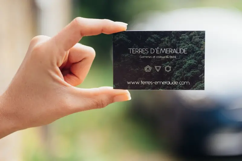 Person holding dark green business card