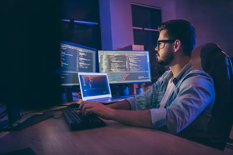 Young man working on his computer with multiple screen