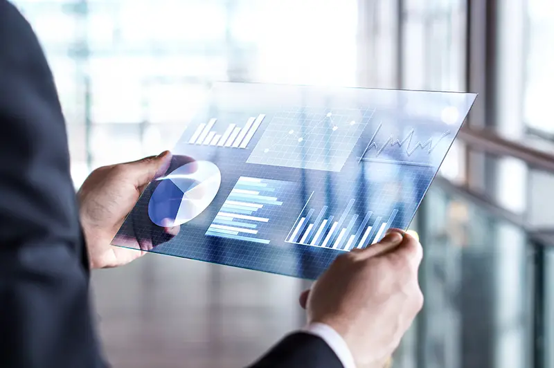 Businessman using virtual touch screen device with data