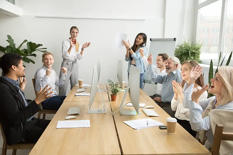 Corporate diverse team colleagues congratulating the male co worker