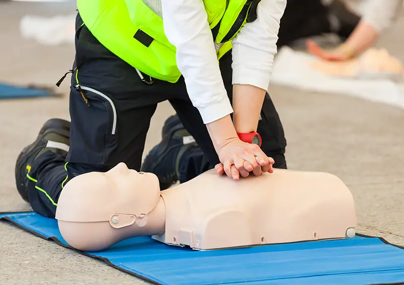 Female instructor showing CPR on training doll