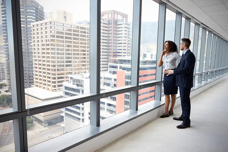 New Business Owners standing inside the Empty Office Window