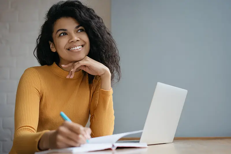 Young happy female student in front of her laptop