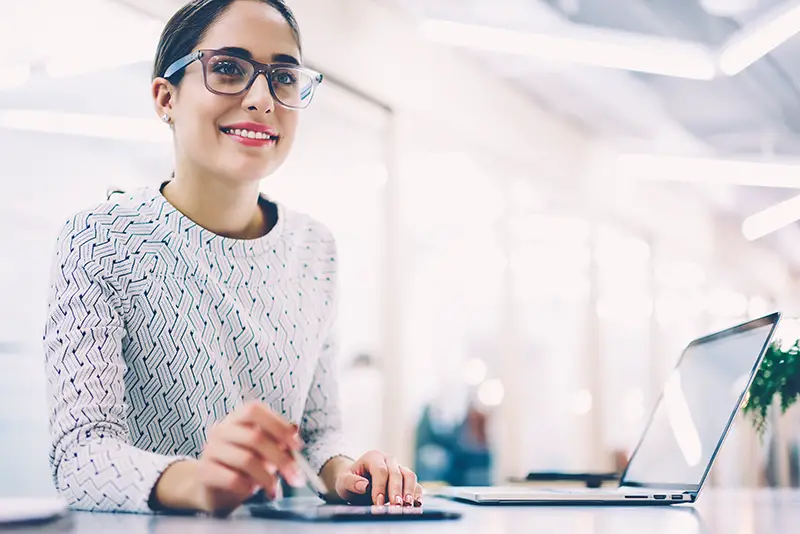 Smiling Female administrative manager sitting in front of her working desk