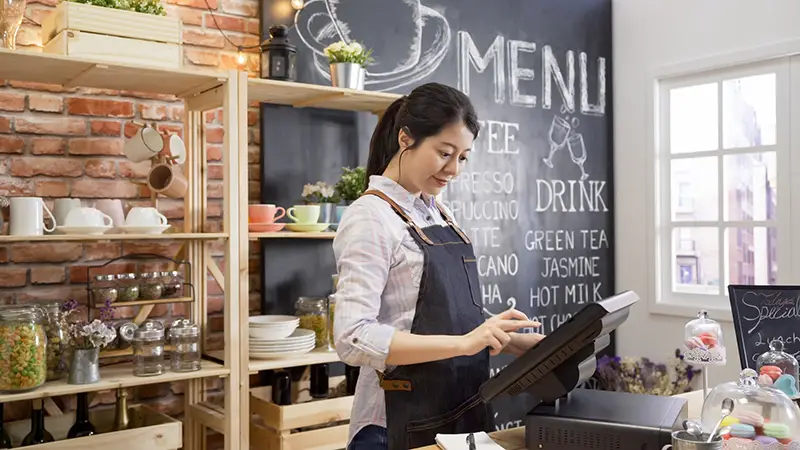 barista using point of sale terminal to run store