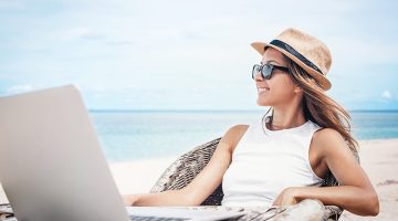 Young woman freelancer working on the beach