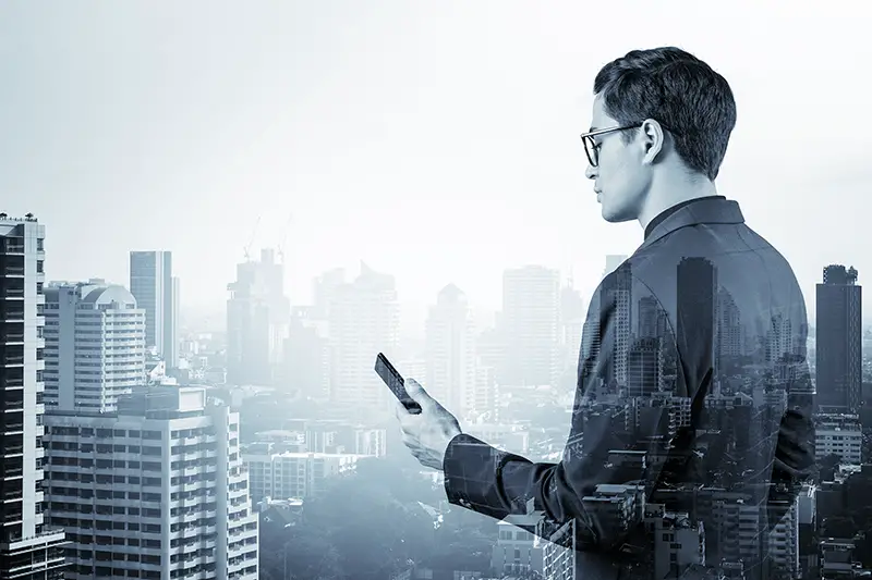 businessman in suit and glasses using phone