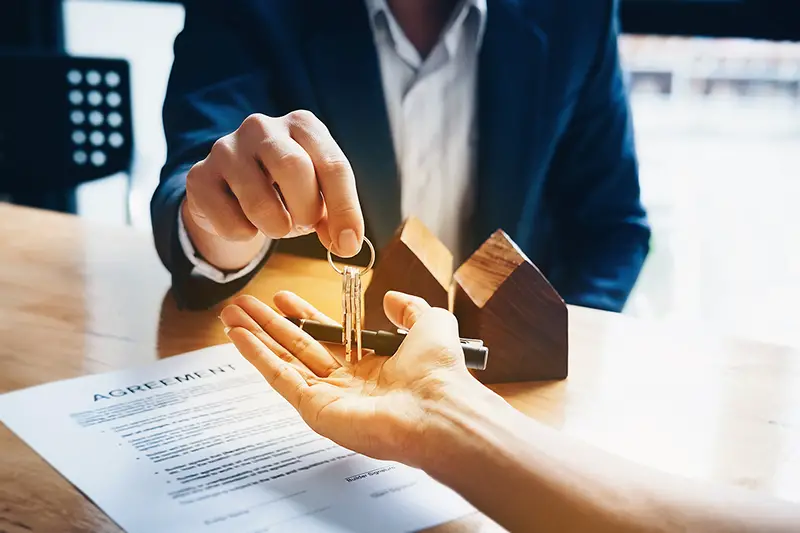 Real estate agent handing over the house key to client