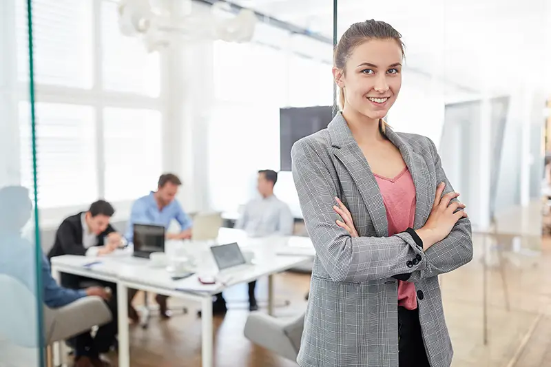 Young successful business woman with crossed arms in start-up office