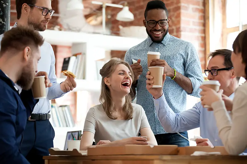 Happy diverse colleagues have fun at lunch