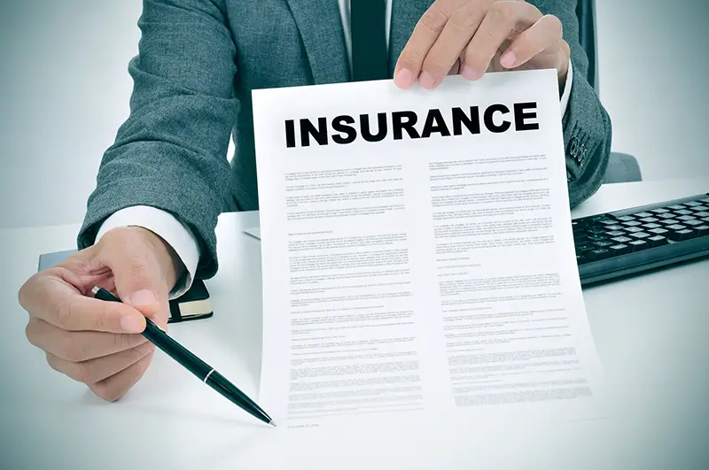 a young man in suit in his office showing an insurance policy