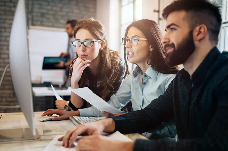 Company employees working in front of computer inside the office