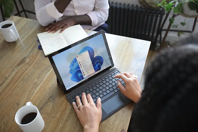 Two people at the table working on their laptop