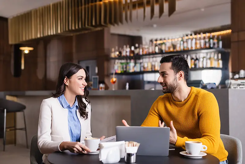 Young man and woman business owner talking inside the restaurant bar