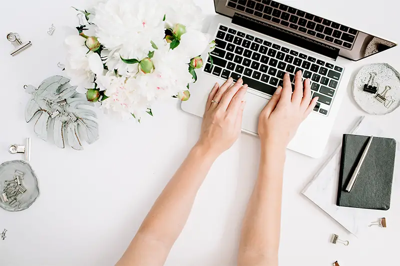 Hand of woman typing on her laptop