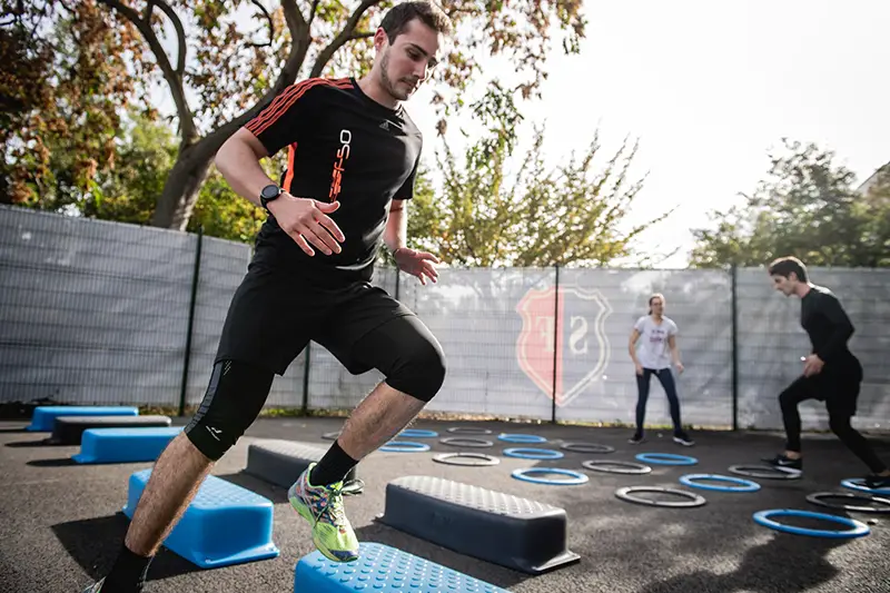 Man in black crew neck t-shirt running on blue trampoline