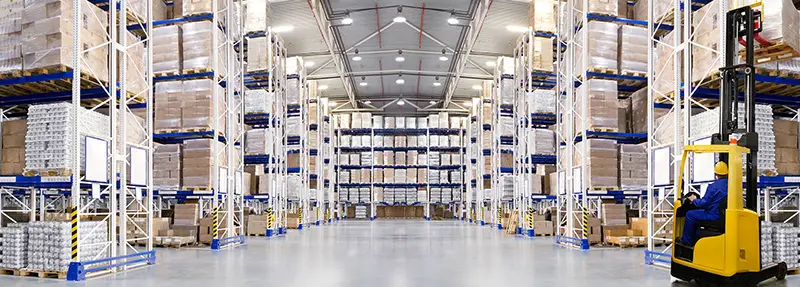 Huge distribution warehouse with high shelves and forklift