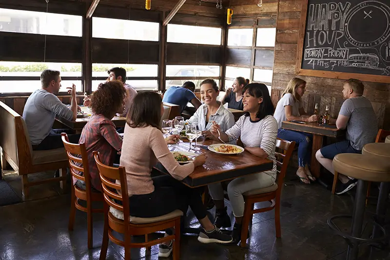 Four female friends at lunch in busy restaurant,