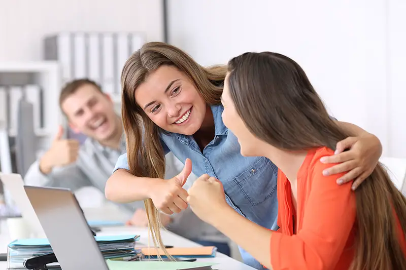 Happy colleagues congratulating to a successful employee