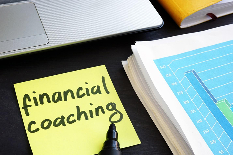 Financial coaching text written on yellow sticker note pad
