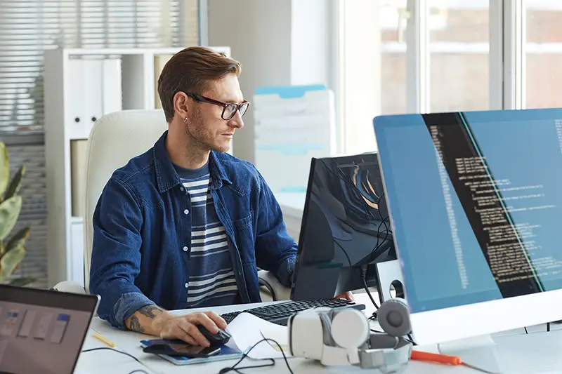 Side view portrait of modern IT developer using computer in office