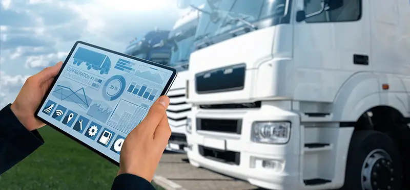 Manager with a digital tablet on the background of trucks