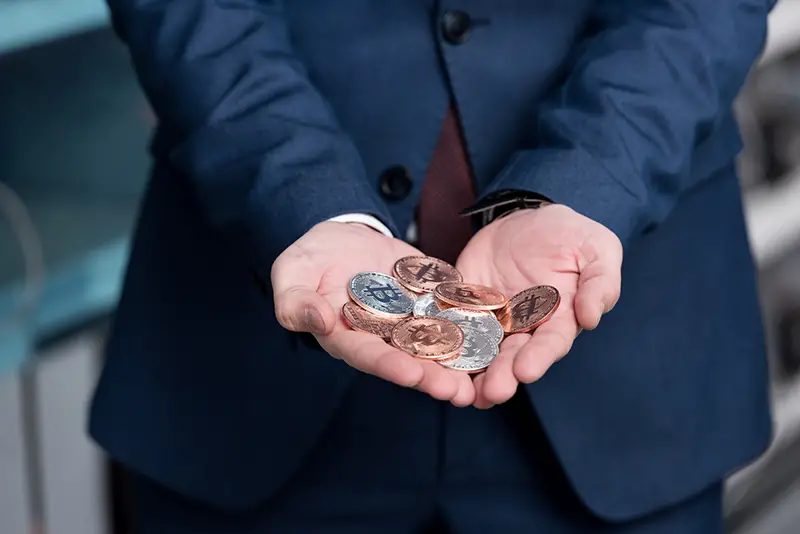 businessman with heap of bitcoin on his hands