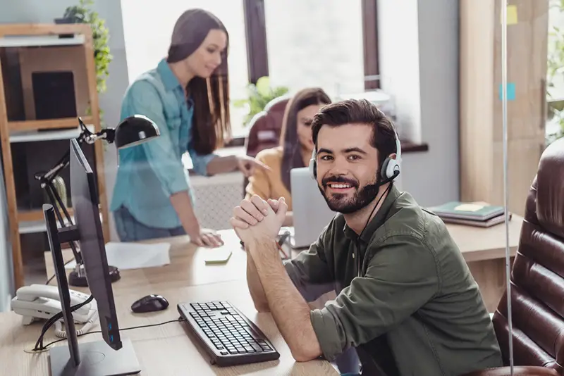 Three employees inside the office sitting in their work station