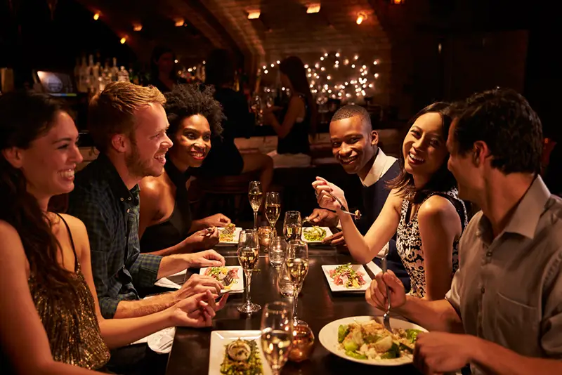 Group Of Friends Enjoying Meal In Restaurant