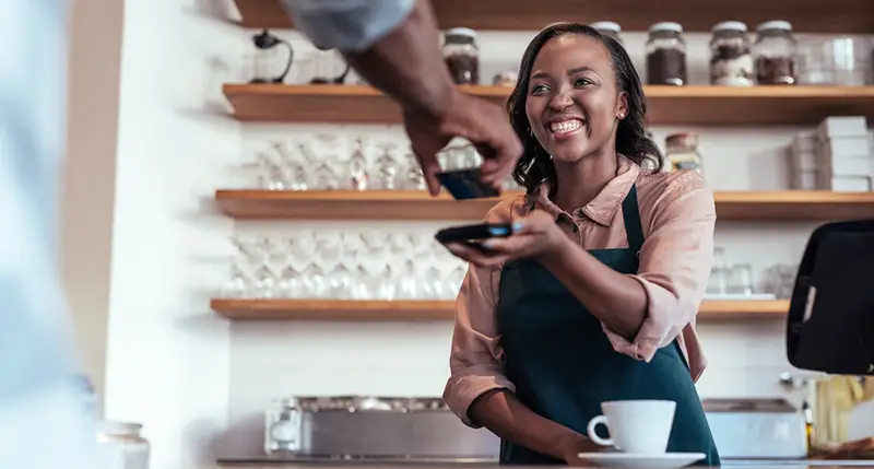 Happy woman assisting the customer in the cashier