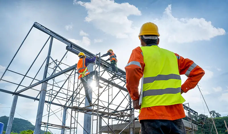 Engineer technician Looking Up and Analyzing an Unfinished Construction Project.