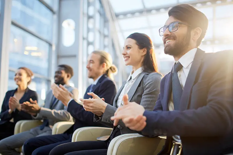 Contemporary business people clapping their hands at conference