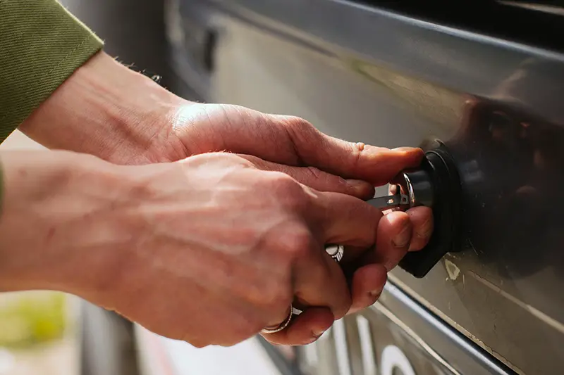 Hands of man unlocking the car trunk