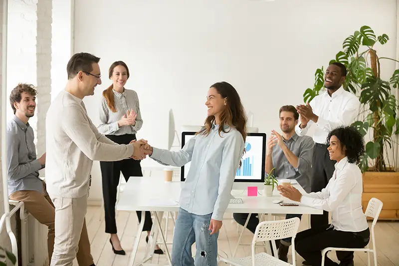 Boss congratulating a young female employee