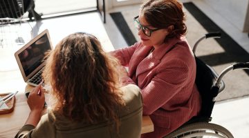 Woman in Red Sweater Wearing Black Framed Eyeglasses Sitting on Wheelchair