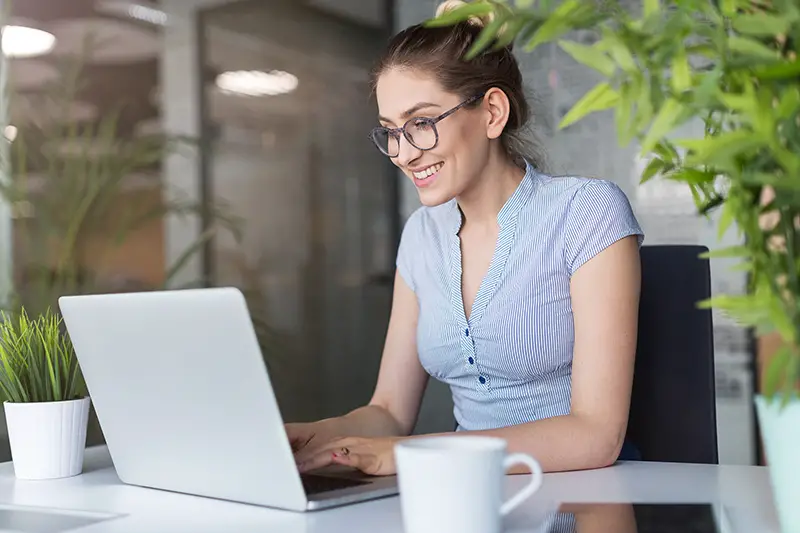 Young business woman working on laptop in office