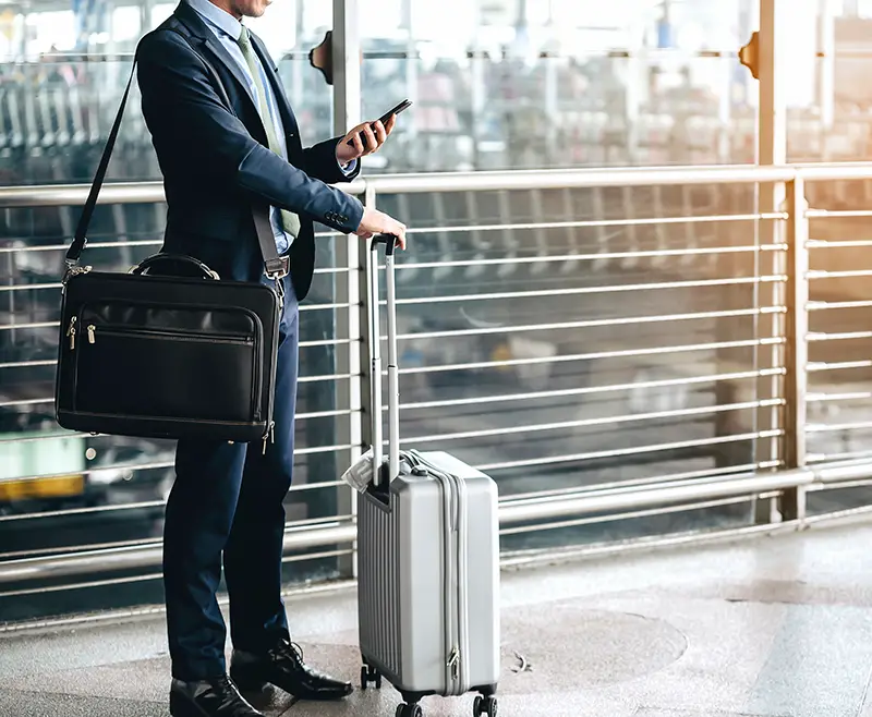 Businessman using smartphone while waiting for a trip in the airport