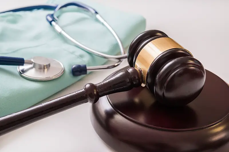 Gavel and stethoscope in background.