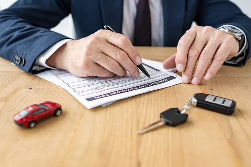 Man signing a car loan agreement
