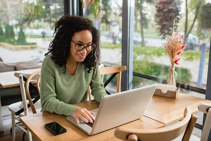 African american freelancer in glasses using laptop for work