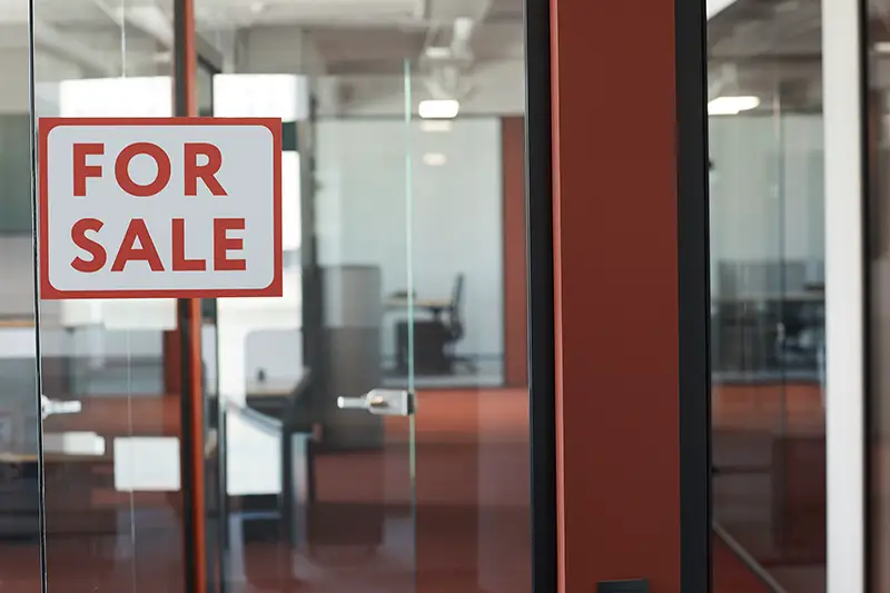 For Sale sign on glass door of empty office rental, copy space