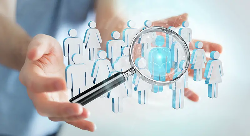 Businessman on blurred using magnifying glass to recruit people