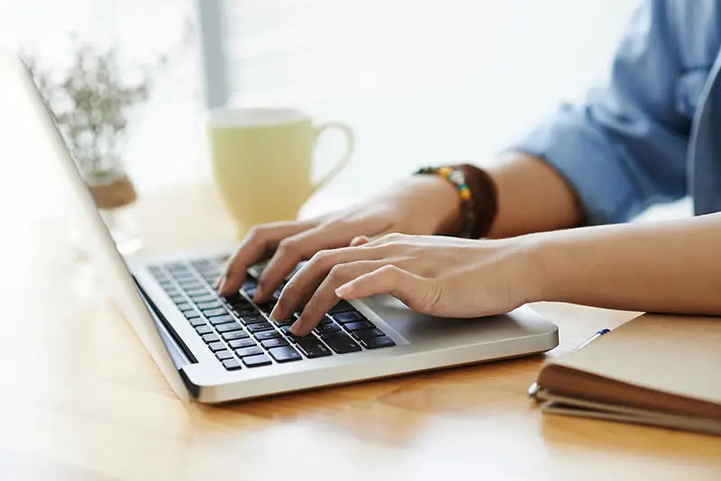 Female hands typing on laptop