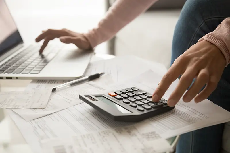 Close up cropped image young woman calculating monthly expenses,