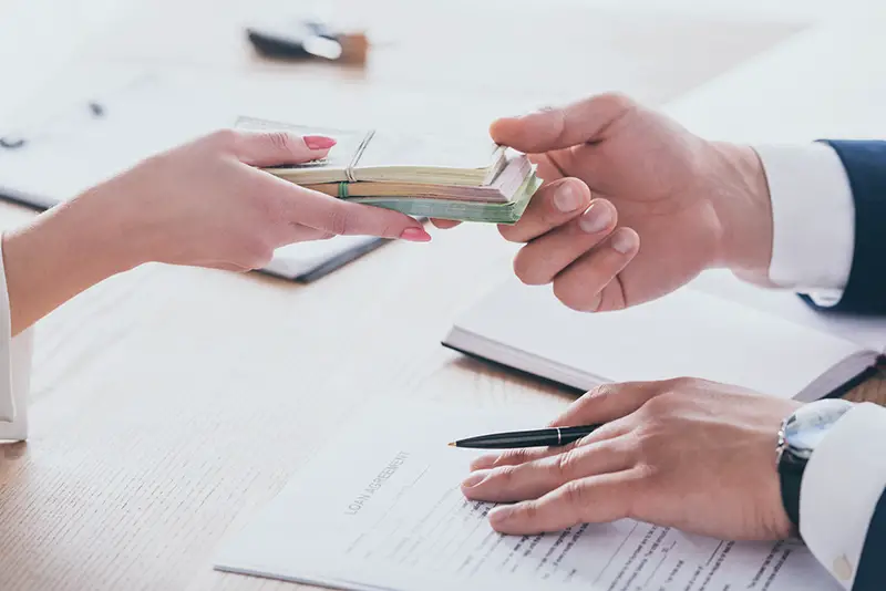 Cropped view of woman giving money to manager